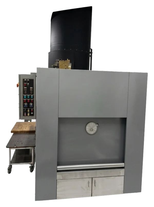 The Pacific Crematory PC-H1 human cremation unit, showing its panelled front, viewing port, loading door, and the control panel and charging table alongside it.